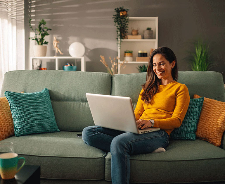 Woman working on laptop in cozy livingroom