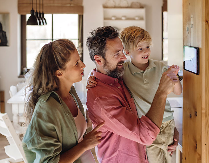 family looking at digital thermostat