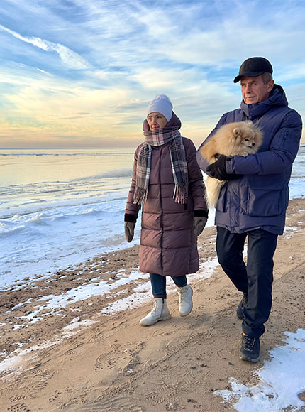 older couple on wintry beach with dog