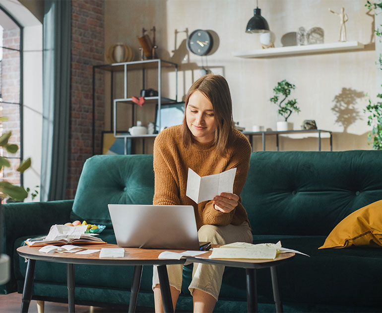 woman on couch working on laptop