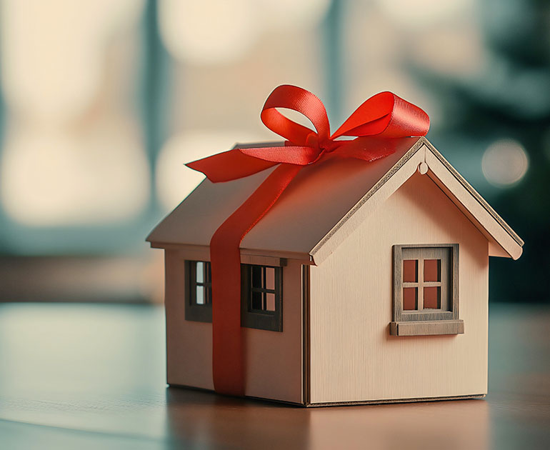 small, wooden house wrapped with a ribbon