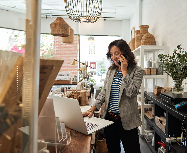 female shop owner working on laptop