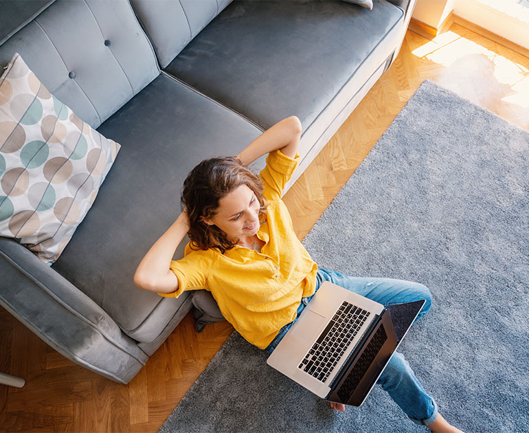 woman sitting on living room floor with laptop