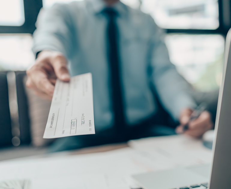 Person handing check to customer