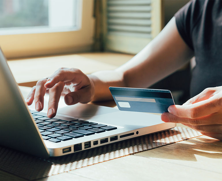 person making credit card purchase on laptop